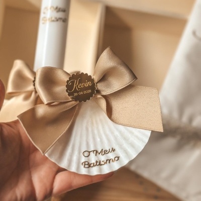 Concha decorativa branca com laço castanho claro e etiqueta dourada personalizada com nome e data