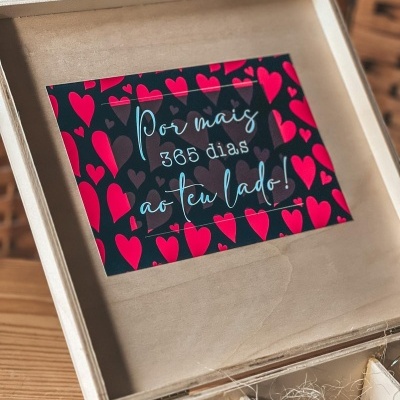 Cartão com corações vermelho e cinza dentro de caixa de madeira