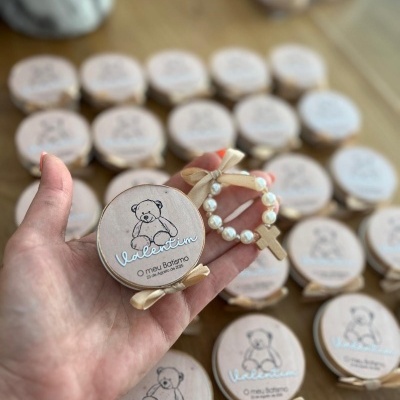 Caixas de madeira com decoração de ursinho e pulseira de pérolas e cruz