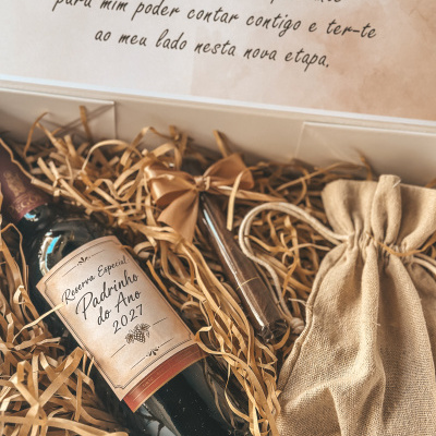 Cesta de presente com garrafa de vinho, saco de tecido e mensagem em português.
