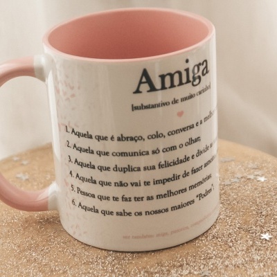 Caneca branca com interior e pega rosa e texto preto sobre madeira rústica