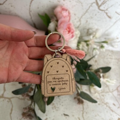 Porta-chaves em forma de mochila castanha clara com texto e tassel salmão