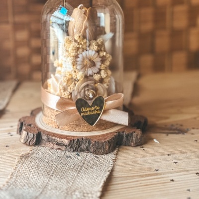 Arranjo de flores secas em cúpula de vidro decorada com fita e coração dourado