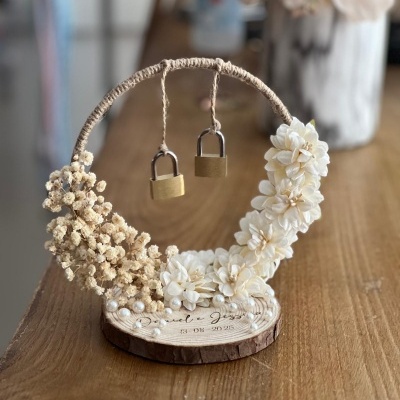 anel de madeira com flores brancas, cadeados pendurados e texto gravado