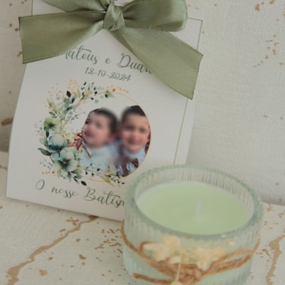 Vela verde clara em vidro texturizado com laço de ráfia e placa decorativa com texto em português e laço verde