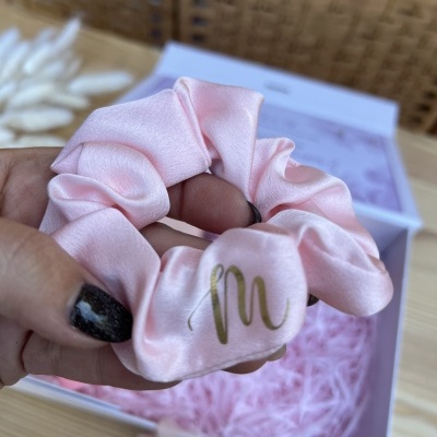 Elástico de cabelo rosa acetinado com letra M dourada