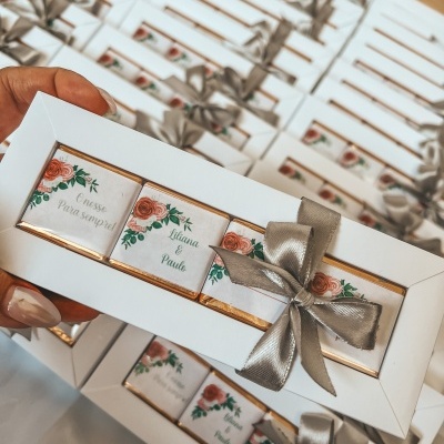Caixa branca com quatro mini chocolates personalizados e laço cinza