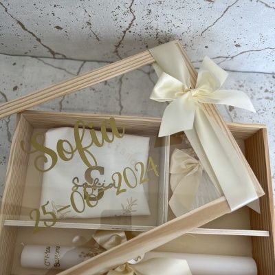 Conjunto caixa madeira com toalha branca, vela e caixa decorada com texto dorado e fita creme.