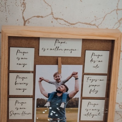 Quadro de madeira com cartões escritos em português e fotografia central, fundo de parede com textura rachada