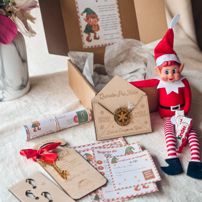 Kit de Natal com duende de roupa vermelha, cartas temáticas e chave decorativa num tecido claro