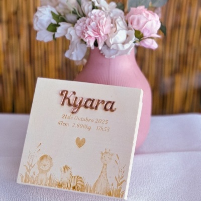 Cartão de nascimento com nome Kyara, data, hora, peso e altura, com ilustrações de animais e vaso rosa com flores ao fundo