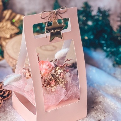 Caixa de presente rosa com flores e pendente de estrela 'Feliz Natal'