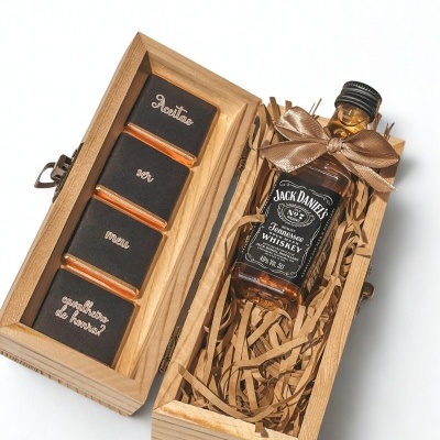 Caixa de madeira com mini garrafa de whiskey e chocolates com texto em português.