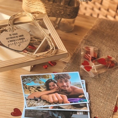 Fotografias de casal, cartão em forma de coração com mensagem, pirulitos vermelhos sobre mesa de madeira