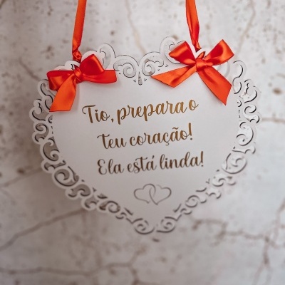 Placa decorativa em forma de coração com laços laranja e texto em dourado