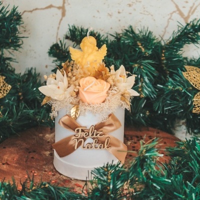 Arranjo decorativo de Natal com anjo e flores na caixa branca com laço e texto FELIZ NATAL