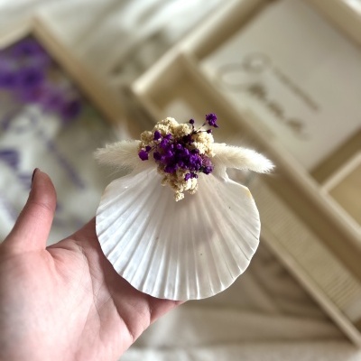 Concha decorativa com flores secas roxas e creme