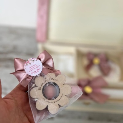 Embalagem triangular transparente com flor de madeira e laço rosa