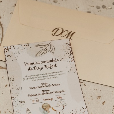 Convite de primeira comunhão com detalhes dourados e envelope bege com letras douradas