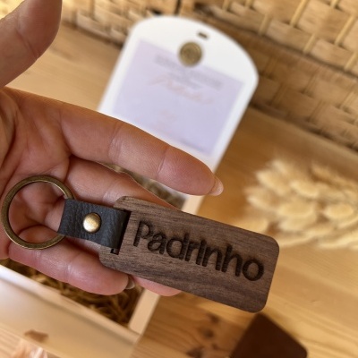 Chaveiro de madeira escura com gravação 'Padrinho' com argola metálica e detalhe em couro preto