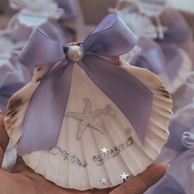 Concha decorativa com fita roxa, pérola e texto metálico