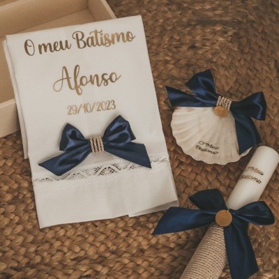 Jogo de batismo com toalha, concha e vela decorados com laço azul