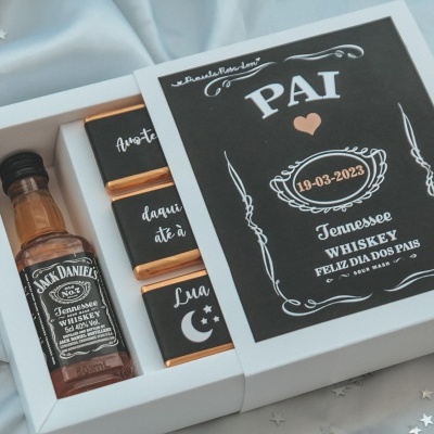 Caixa de presente com mini garrafa de whiskey Jack Daniel's e chocolates em papel preto em tecido azul claro