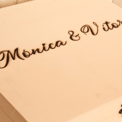 Caixa branca com texto Mónica & Vítor em relevo preto
