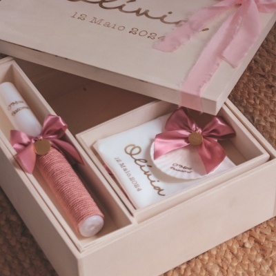 Caixa de madeira com vela, corda rosa e certificado decorados com fitas cor de rosa.