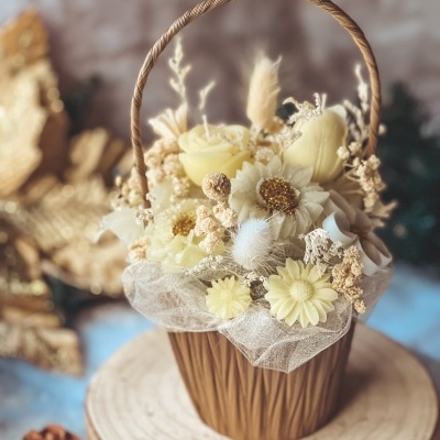 Cesto decorativo com flores artificiais amarelas e creme em base de madeira