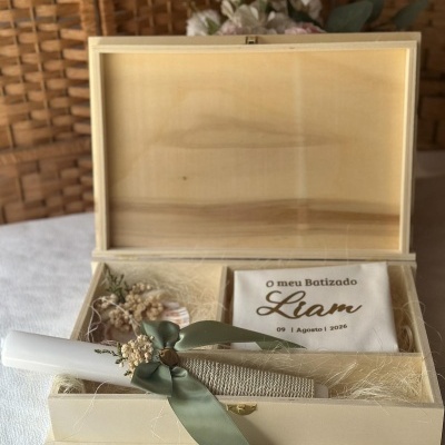 Caixa de madeira com vela decorada e tecido com texto de batizado.