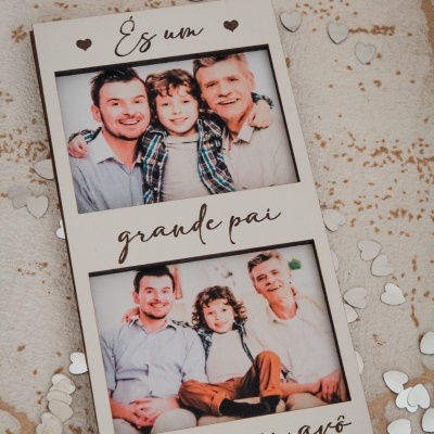 Placa decorativa com fotos de família e texto em português rodeada de corações brancos