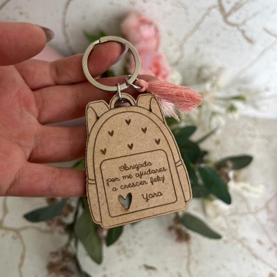 Chaveiro de madeira em forma de mochila com mensagem gravada e tassel rosa