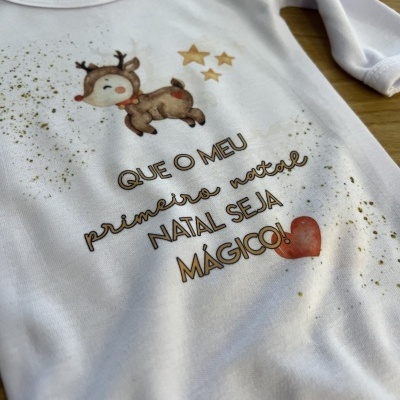 Body branco de bebé com estampa de veado, estrelas e texto alusivo ao primeiro Natal