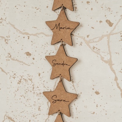 Estrelas de cortiça com nomes escritos à mão penduradas por um fio