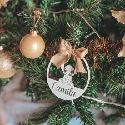 Ornamento redondo branco com desenho do Stitch e nome Camila pendurado numa árvore de Natal