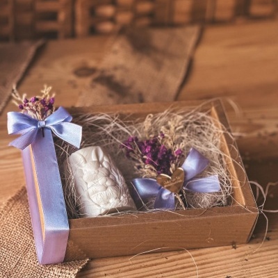 Caixa de presente com vela branca e raminho seco com laço azul