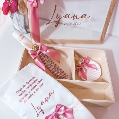 Conjunto de lembranças de batismo com vela, concha e toalha bordada na caixa de madeira clara