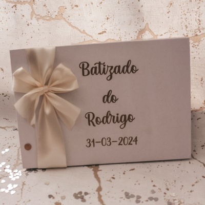 Cartão branco com laço creme e texto preto sobre superfície marmoreada