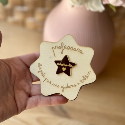 Placa decorativa em madeira clara com estrela preta e texto para professora