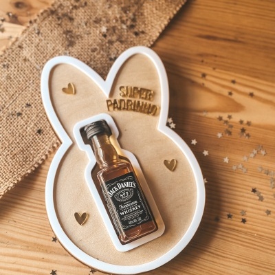 Mini garrafa de whiskey Jack Daniels numa base de madeira em forma de cabeça de coelho com texto SUPER PADRINHO
