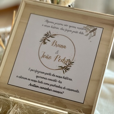 Convite de casamento em caixa de madeira com texto e detalhes florais