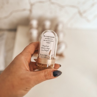 Frasco pequeno de vidro com rolha e etiqueta com texto em português