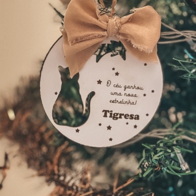 Enfeite de Natal redondo em madeira com laço bege e corte de gato pendurado em árvore de Natal verde