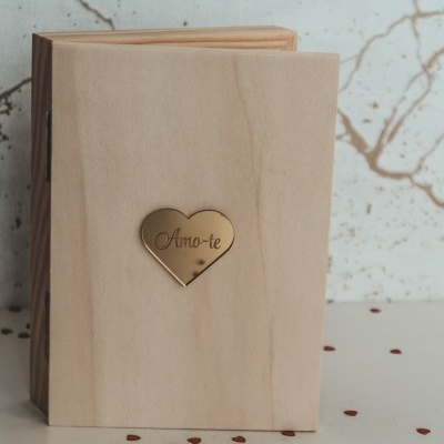 Livro em madeira clara com coração dourado e texto Amo-te