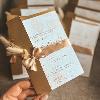 Convite de batizado em papel branco texturizado com fita castanha e raminho seco
