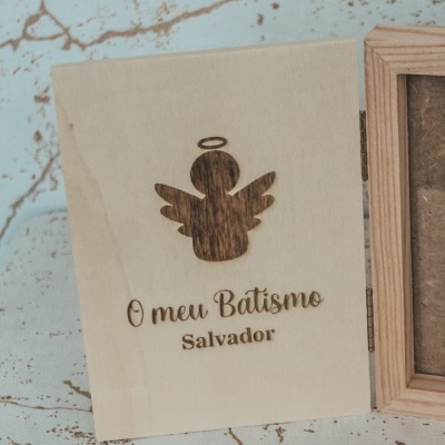 Caixa de madeira com gravação de anjo e texto sobre batismo