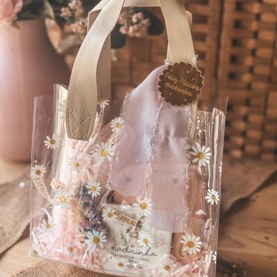 Mala transparente com margaridas, alças bege e etiqueta Feliz Páscoa madrinha