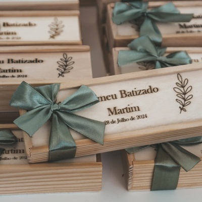Caixas de madeira com texto gravado e laços verdes para batizado