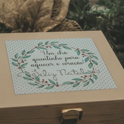 Caixa de madeira para chá com etiqueta decorativa e texto de Natal